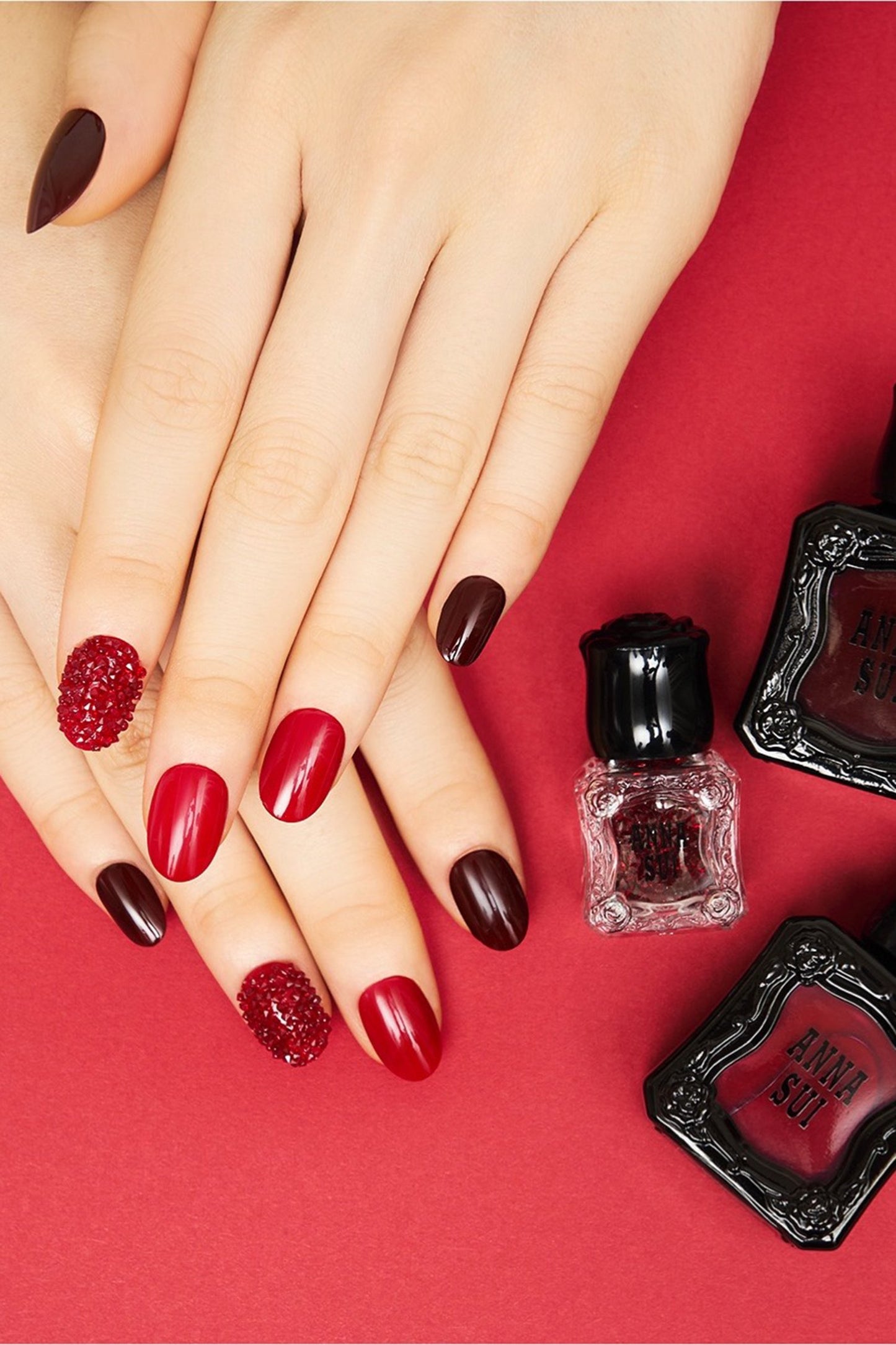 Hands with Nail Polish ANNA RED and DARK CHERRY color, Anna Sui bottle, black container