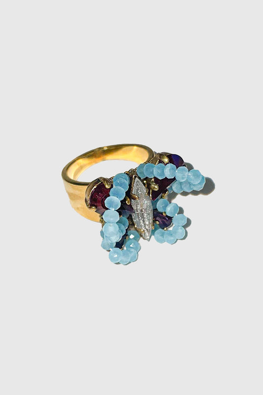 Butterfly ring with baby blue beads, body with an oval gemstone, dark red wing