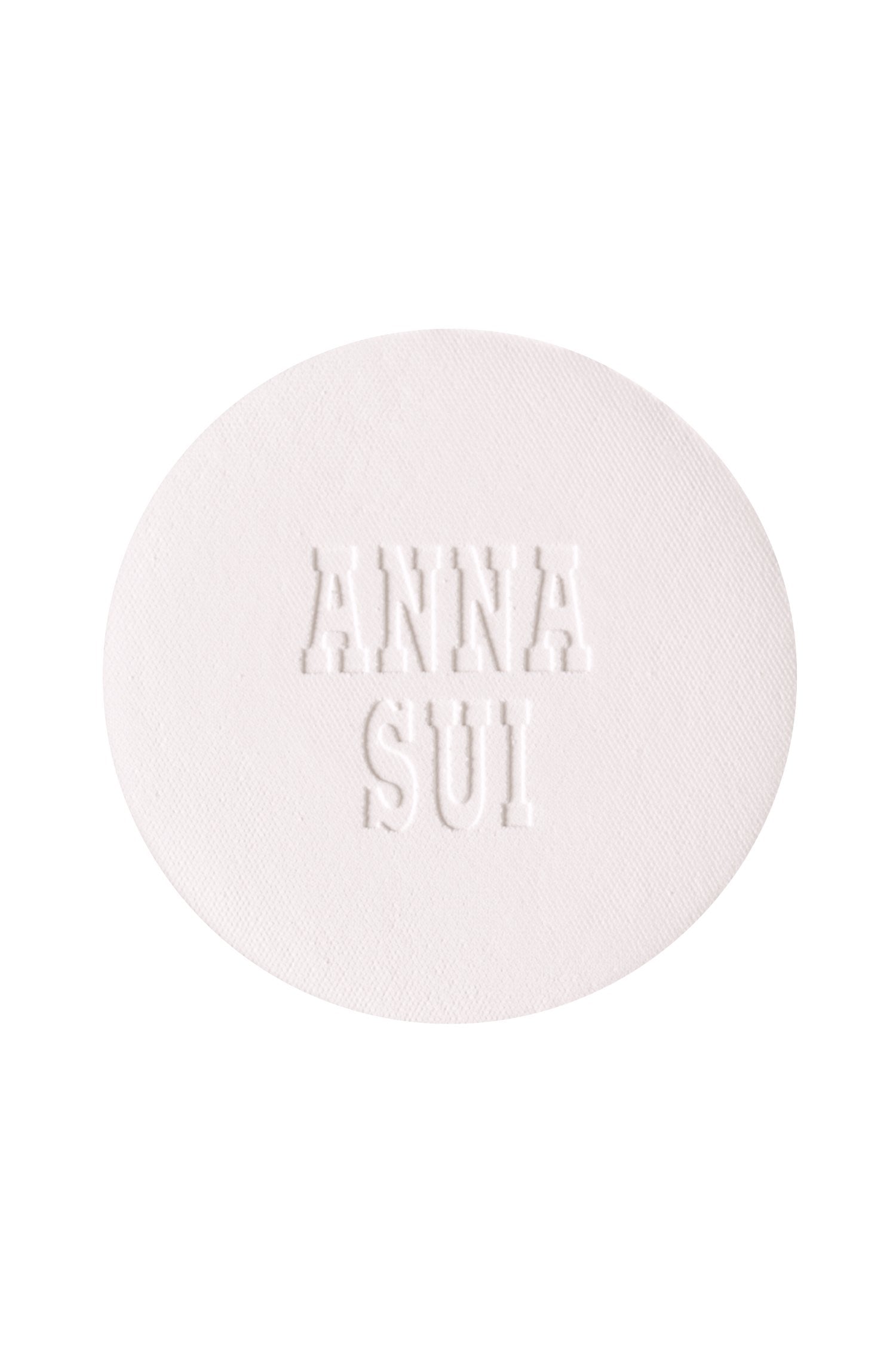 A round powder refill with engraved Anna Sui