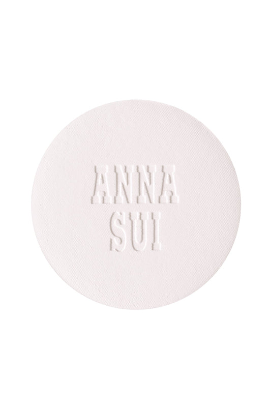 A round powder refill with engraved Anna Sui.