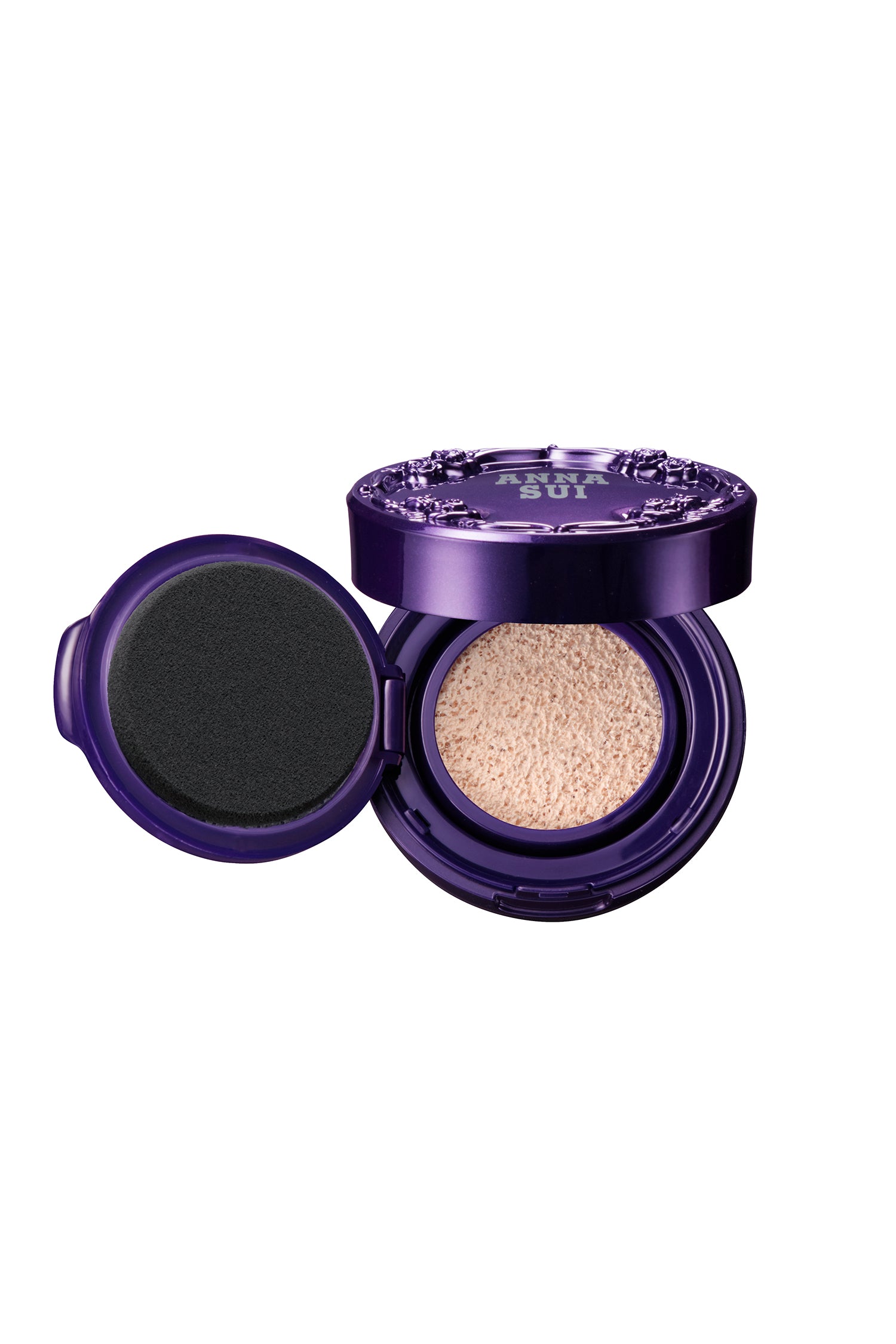 Purple round case, raised rose pattern and Anna Sui label, bottom, liquid face powder, on the left an open lid with a cushion