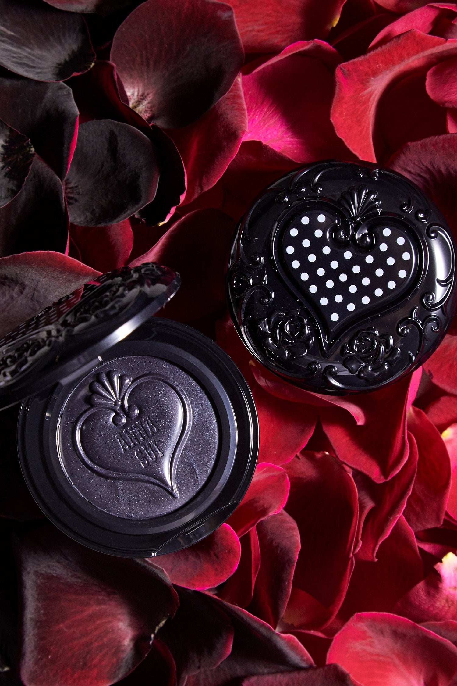 2-Cream blush in round black case, 1 open 1 closed, top lid shows an heart with white dots in it